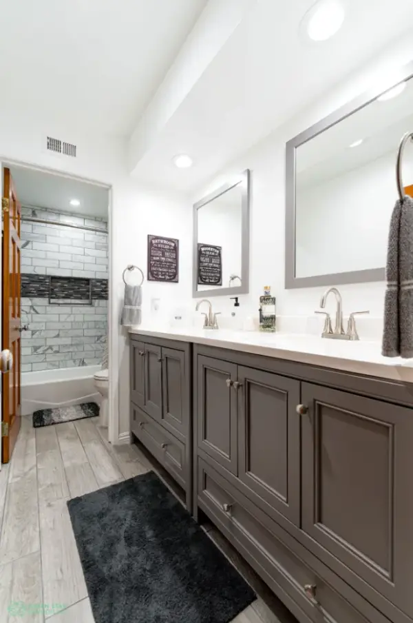 Modern bathroom remodel in Calabasas featuring a double grey vanity with white countertops, silver faucets, and two rectangular mirrors.