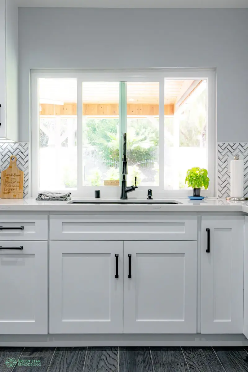 Modern kitchen sink framed by white shaker cabinets in a Santa Clarita remodel by Green Star Remodeling.