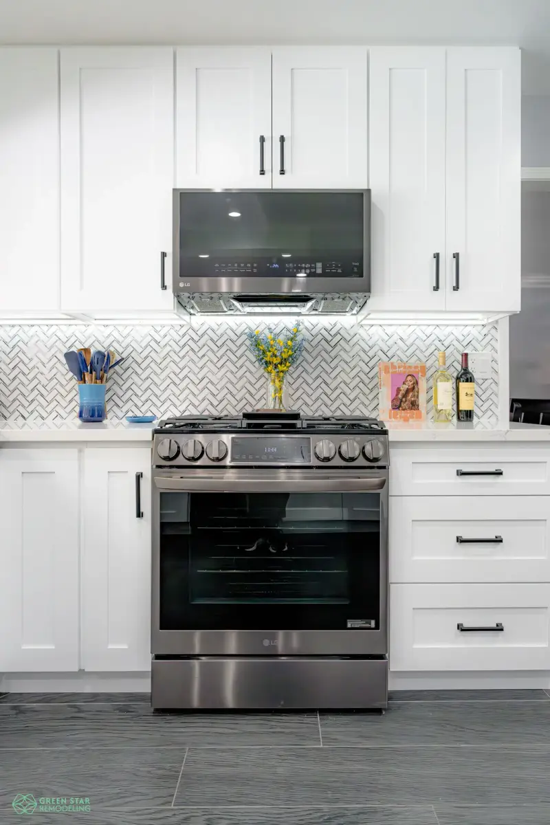 Modern white kitchen remodel in Santa Clarita with a large center island and dark wood flooring.