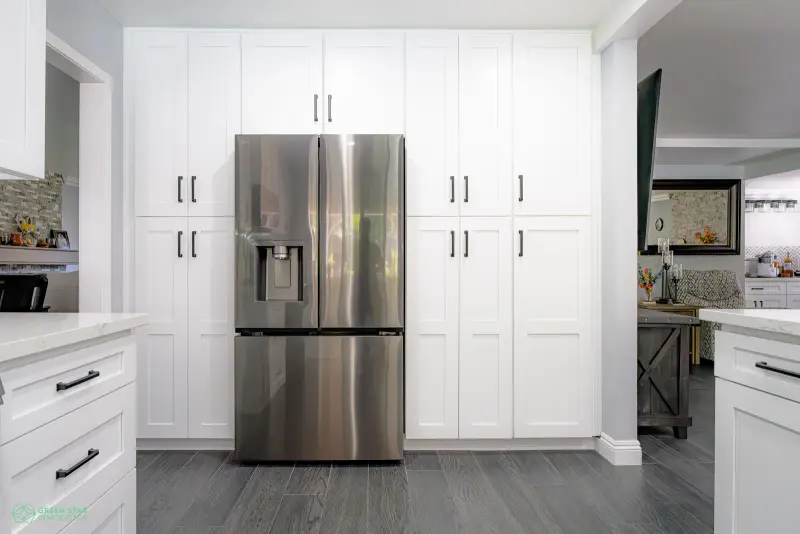 White shaker pantry cabinets framing a stainless steel refrigerator in a Santa Clarita kitchen remodel.